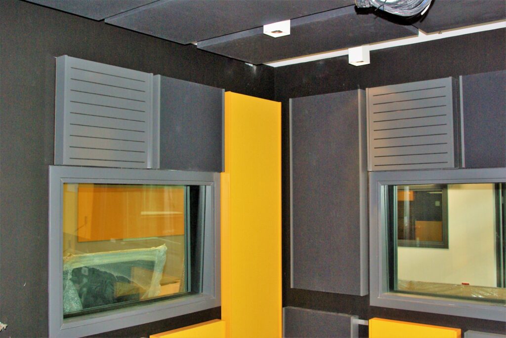 Serenity fabric acoustic wall panels installed in a television broadcast studio with acoustic treatment surrounding studio viewing windows and recording spaces