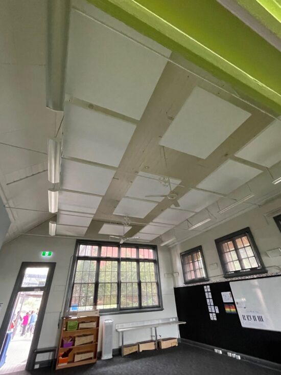 Acoustic Panels for classroom, White acoustic ceiling panels suspended to reduce reverberation in a large classroom area.