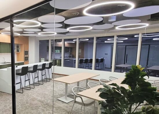 Circular acoustic ceiling clouds with Decragroove wall panels in an open-plan office by Sontext.
