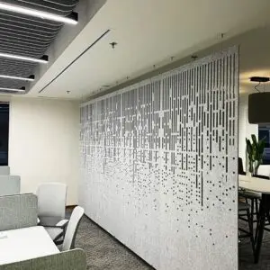 Decrasound hanging acoustic screen with vertical cut pattern installed in an open-plan office for sound control and visual privacy.