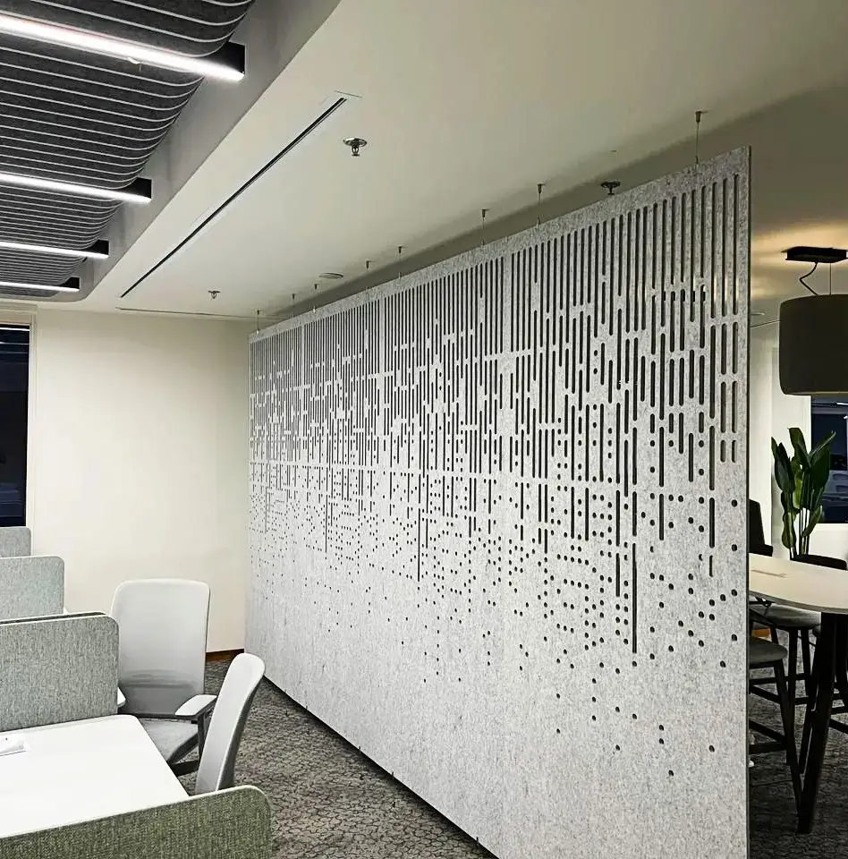 Decrasound hanging acoustic screen with vertical cut pattern installed in an open-plan office for sound control and visual privacy.