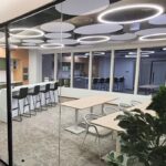 Circular grey acoustic ceiling panels by Decrasound with integrated lighting, installed in a modern boardroom for improved sound control and architectural design.