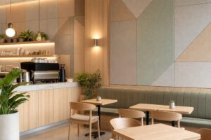 Modern café interior with geometric acoustic wall panels above banquette seating.